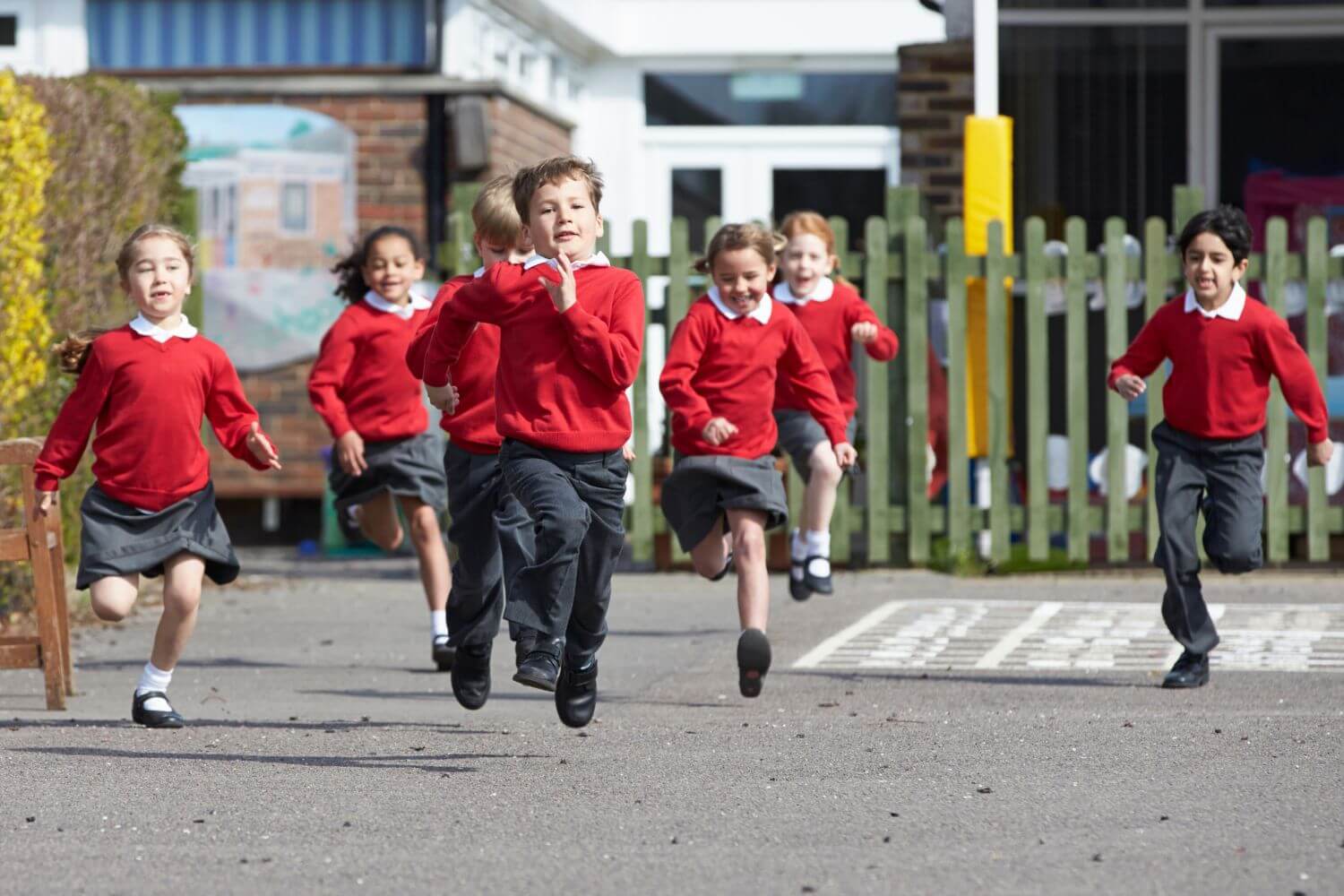 Primary school children running excitedly through their school grounds on Outdoor Classroom Day.