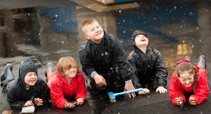 Children enjoy wet weather in their playground
