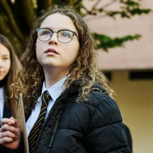 A girl examining the environment of her outdoor classroom at secondary school.