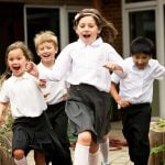 Primary school children running excitedly through their school grounds on Outdoor Classroom Day.