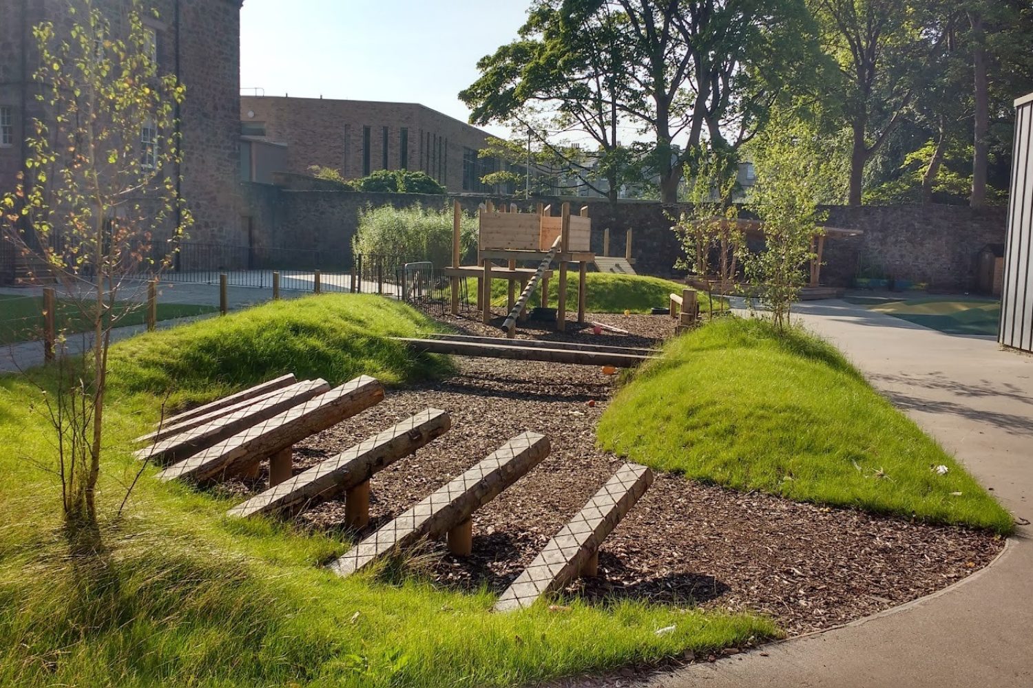 Grassy berms and mounds surrounded by mulch in climate ready school grounds.