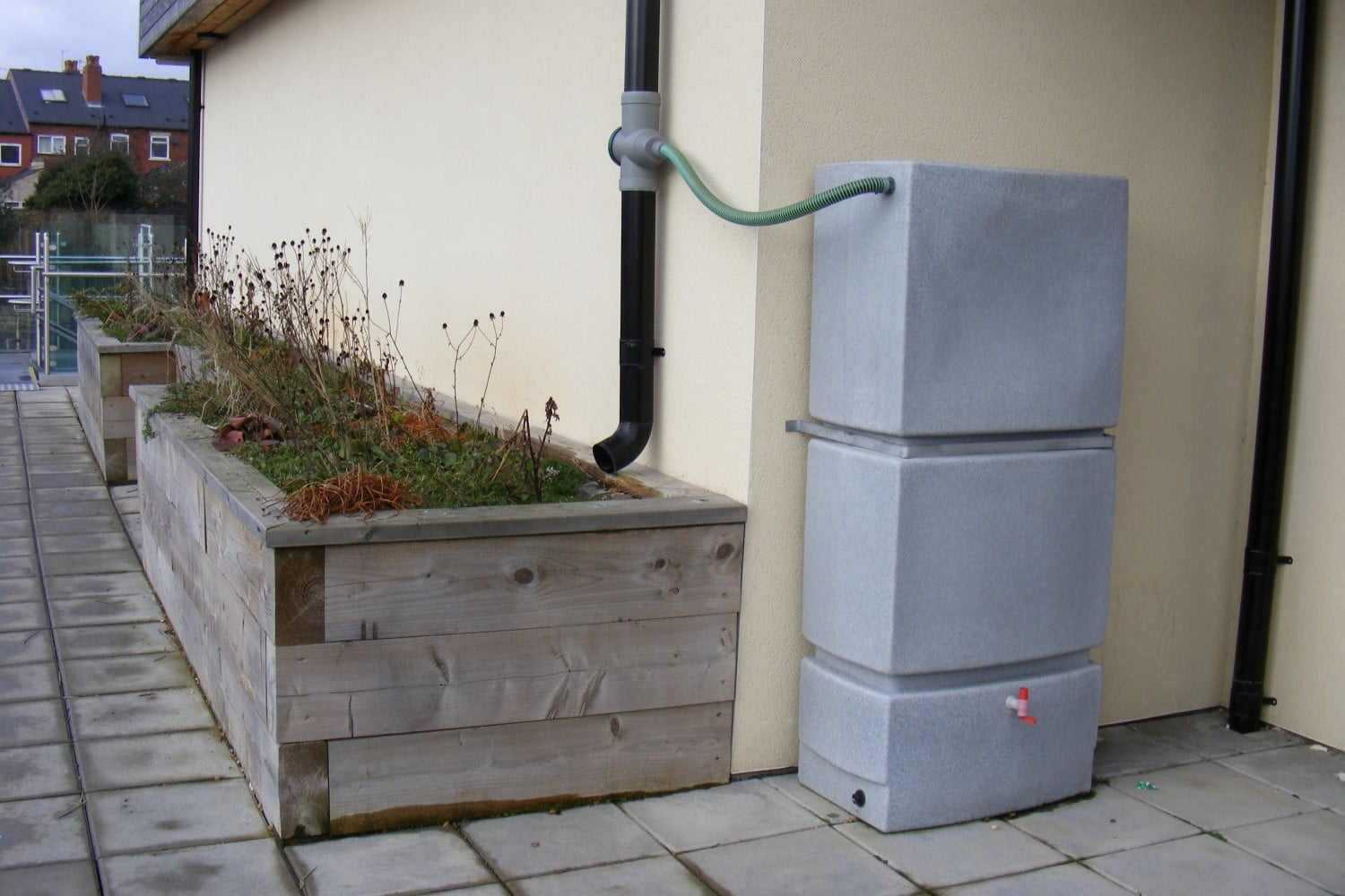 A downpipe cascade garden feeding rain water from the roof into raised beds in climate ready school grounds.