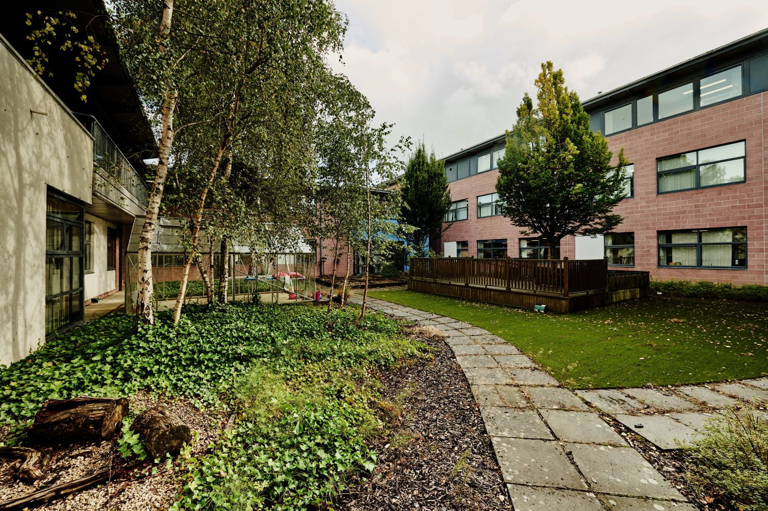 Paved paths surrounded by permeable surfaces to slow rain water run off in climate ready school grounds.