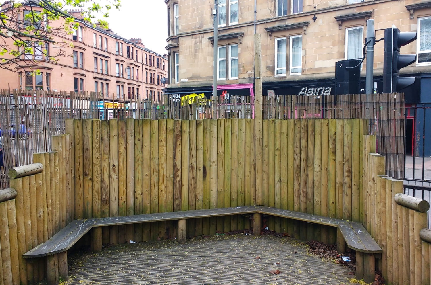 A fenced area with seating to shelter an urban playground from wind and pollution as part of some climate ready school grounds.