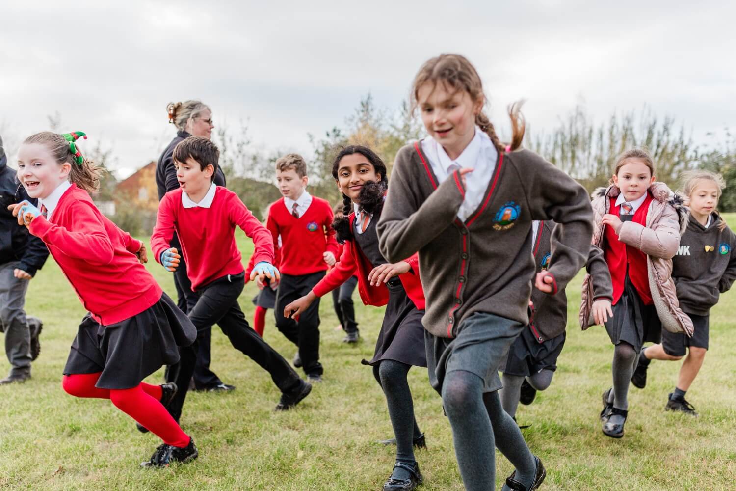 School children running across their grassy school grounds on Outdoor Classroom Day.