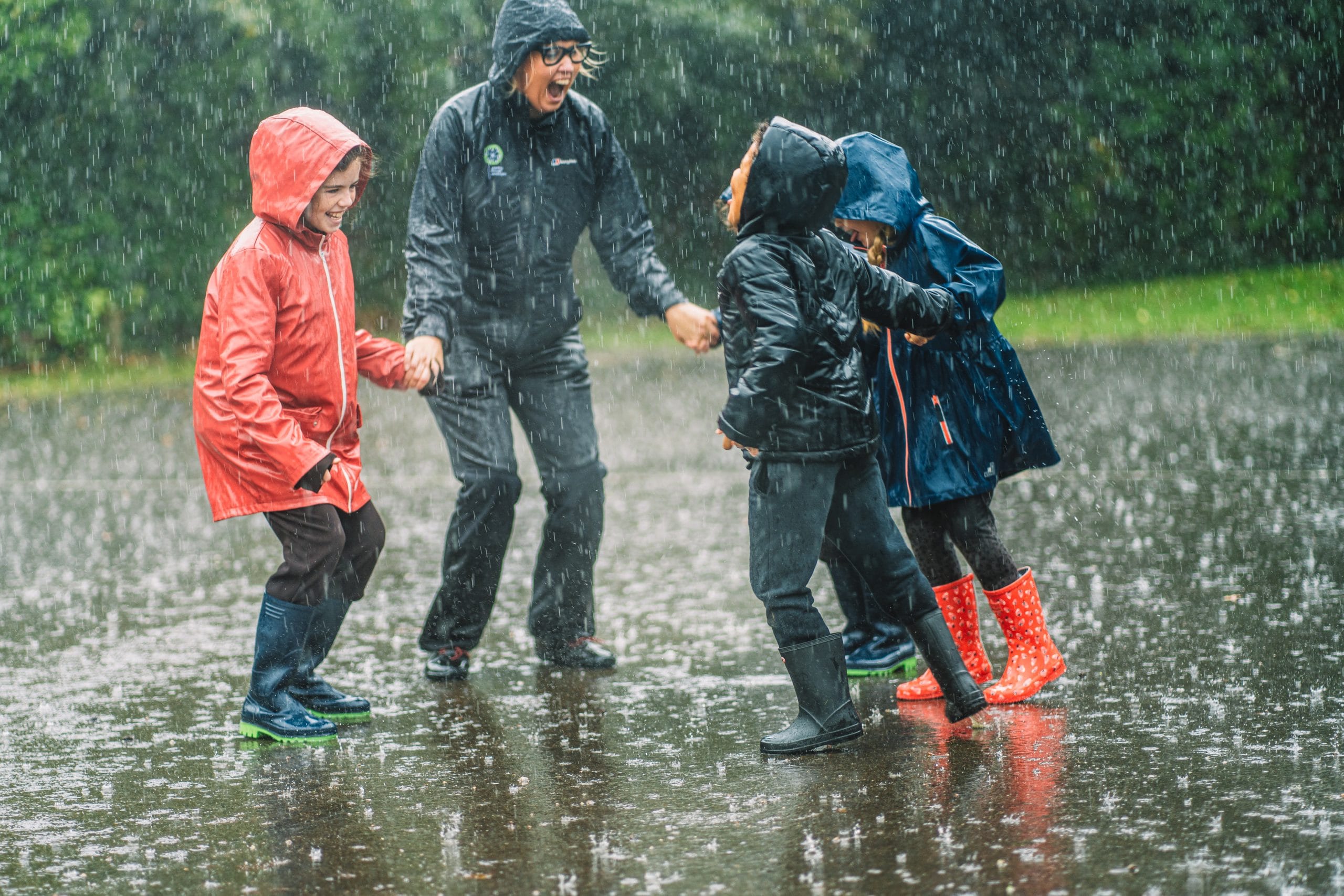 Carley Sefton plays in the rain with a group of children.