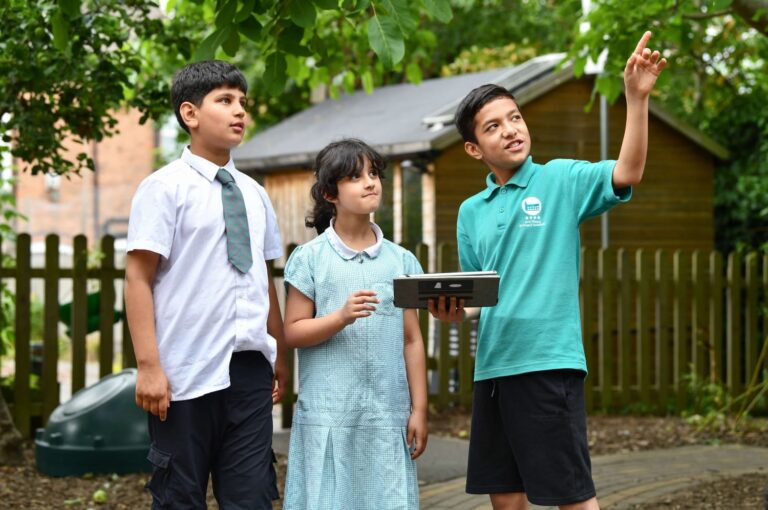 Children exploring nature with technology.