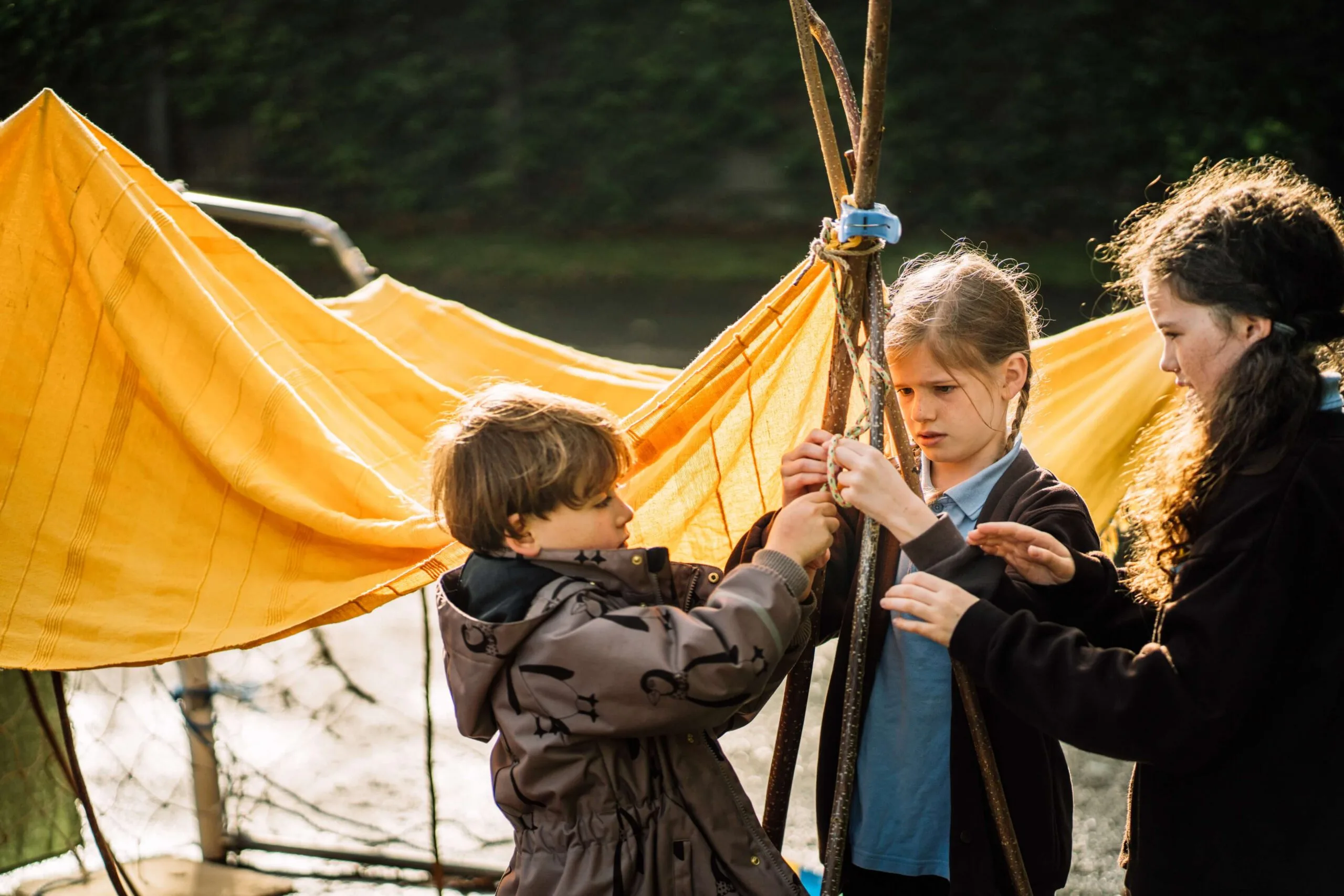 Children building a structure outdoors.