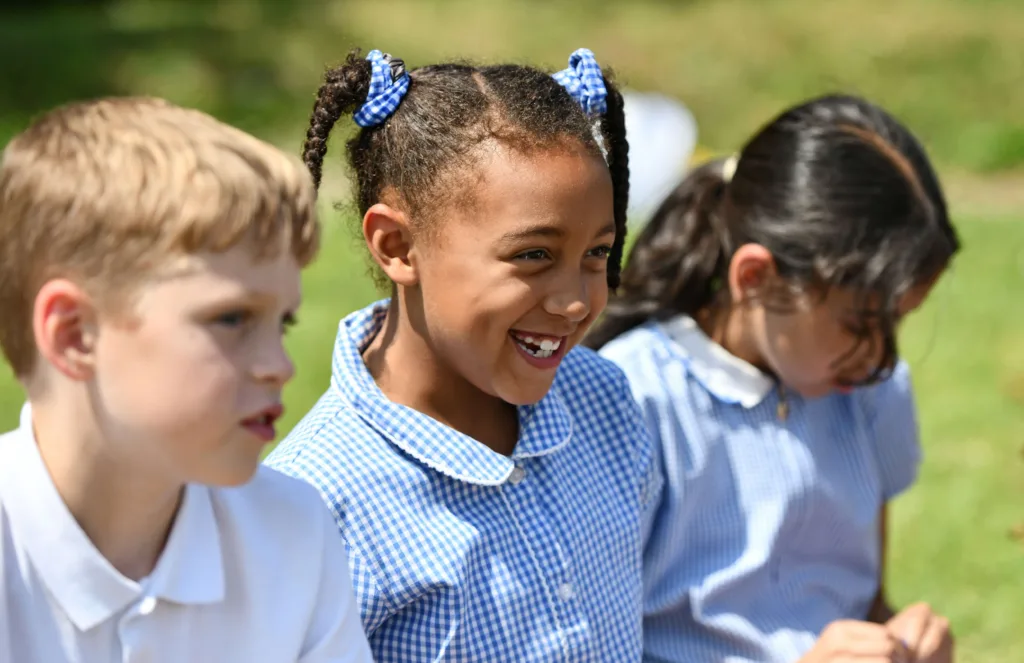 Children sitting outdoors in sunlight.