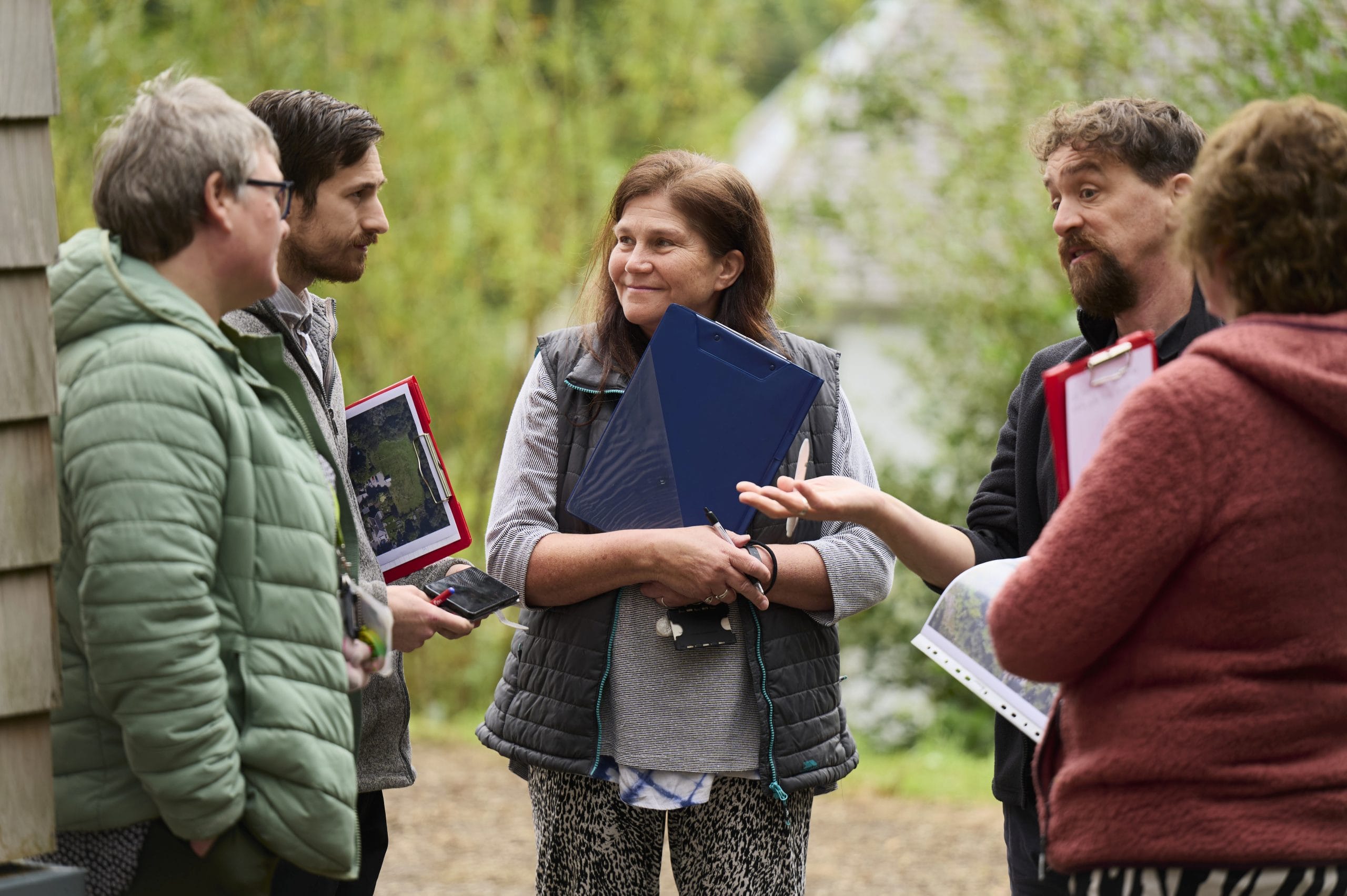 Teachers stand in a group outdoors in the school grounds