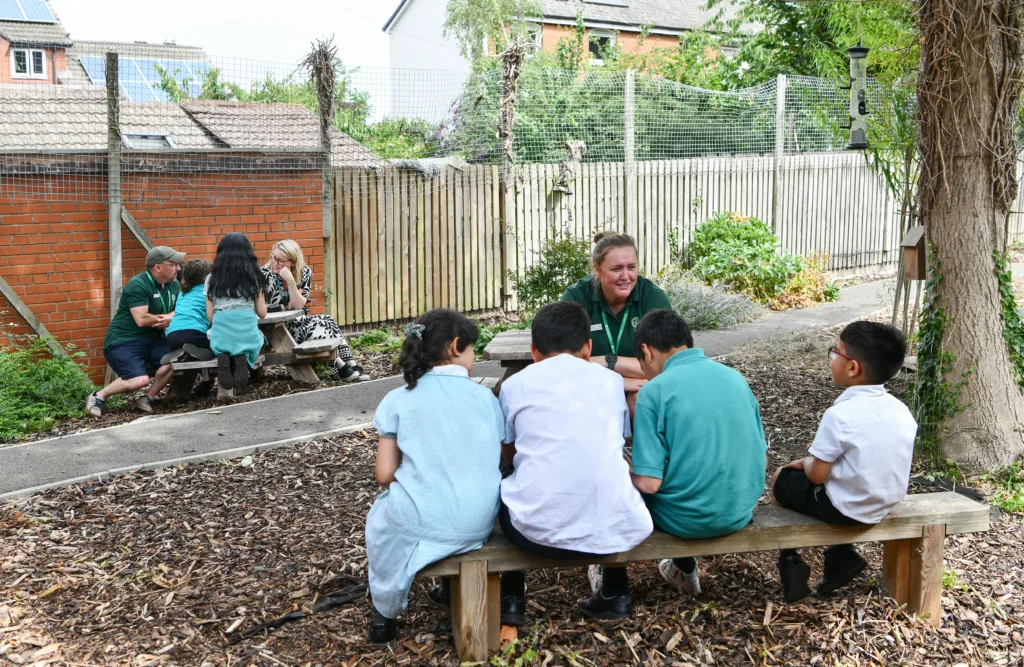 Groups of children and adults in school grounds